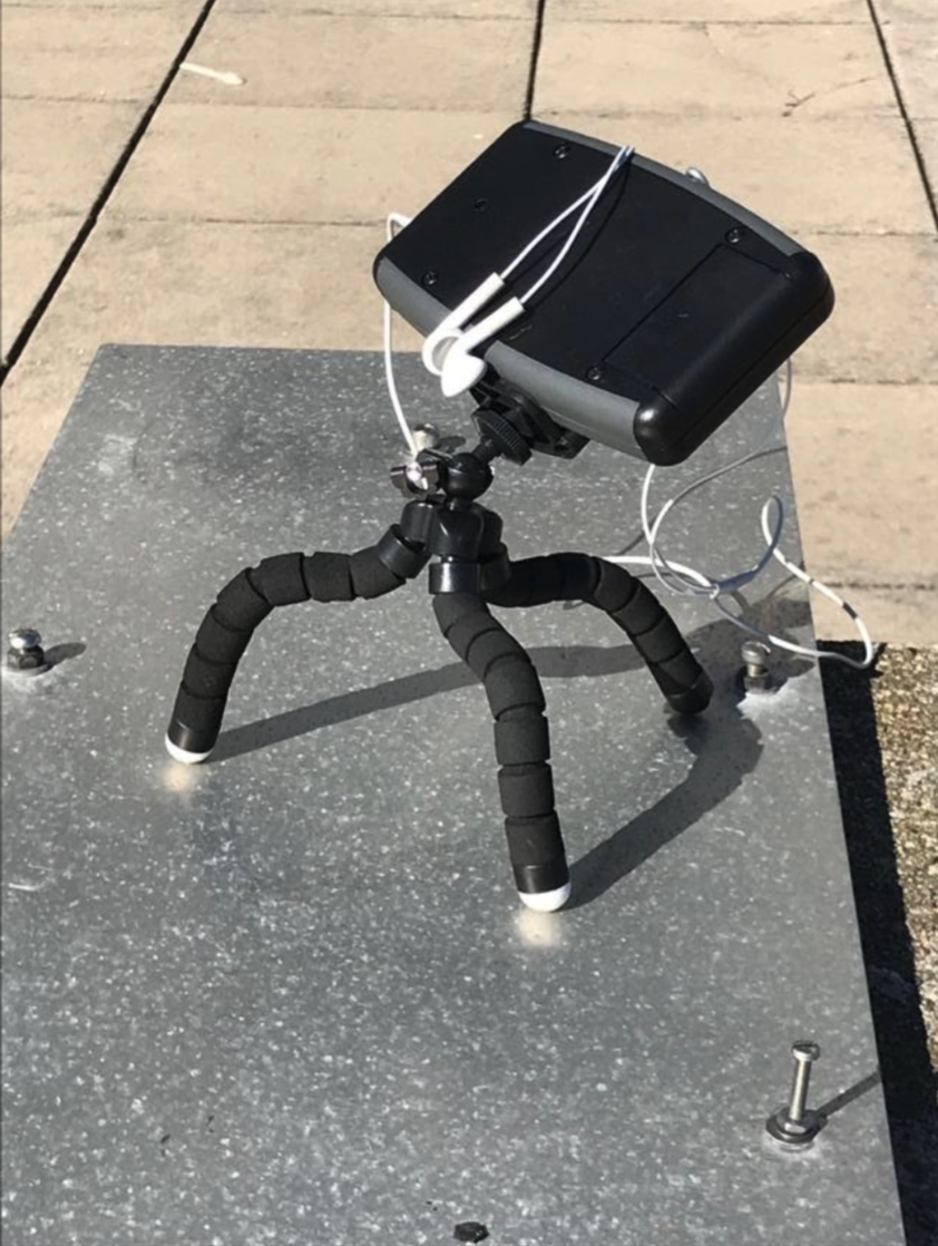 LightSound device on a bendable tripod, with headphones attached.